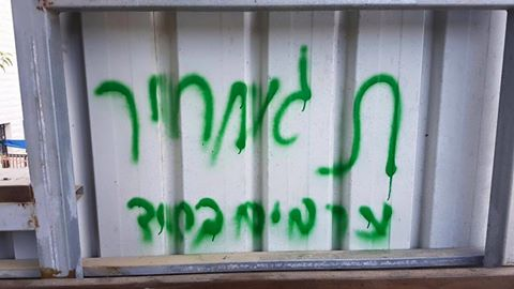 צילום: דוברות המשטרה כתובות בעברית וערבית רוססו על קיר באבו גוש