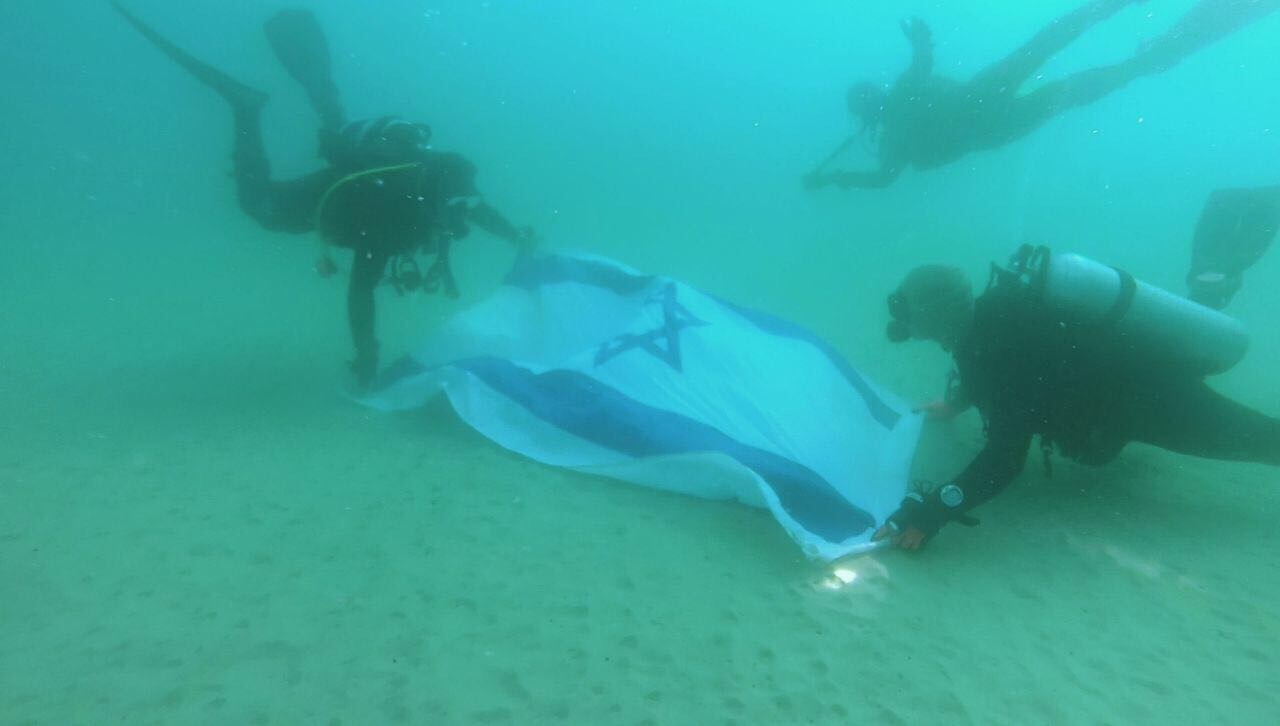 צוללים בחופי תל אביב עם דגל ישראל